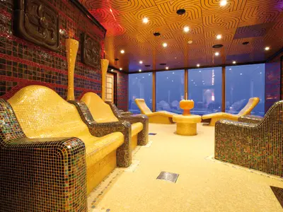 Entspannungsraum im Samsara Spa an Bord der Costa Deliziosa mit beheizten Mosaik-Liegen und Blick durch große Panoramafenster.