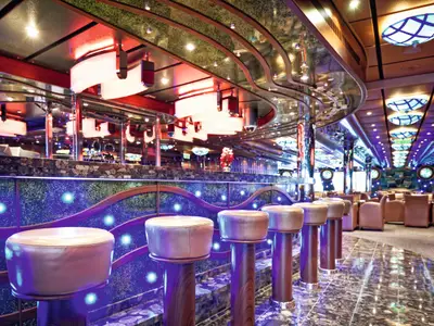 Die Bar Topkapi an Bord der Costa Fascinosa besticht durch moderne Barhocker, geschwungene Linien und eine farbenfrohe Beleuchtung.