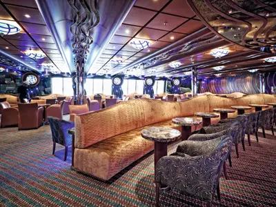 Die modern gestaltete Grand Bar Topkapi an Bord der Costa Fascinosa mit geschwungenen Sofas, Sesseln und runden Tischen.