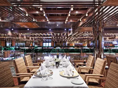 Festlich gedeckte Tische mit Gläsern und gefalteten Servietten im glanzvollen Gattopardo Restaurant an Bord der Costa Fascinosa.