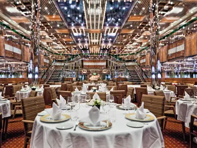 Das prachtvoll gestaltete Restaurant Otto e Mezzo an Bord der Costa Fascinosa mit elegant gedeckten runden Tischen.