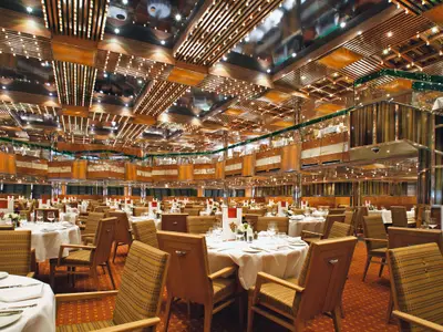 Das prachtvolle, mehrstöckige Restaurant Il Gattopardo an Bord der Costa Fascinosa mit elegant gedeckten Tischen und warmer Holzoptik.