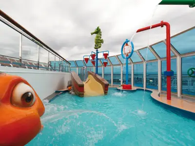 Ein bunter Kinder-Wasserbereich an Bord der Costa Favolosa mit kleiner Rutsche, Seepferdchen-Dekoration und Wasserfontänen.