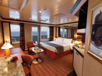 Die gemütliche und elegante Samsara Suite an Bord der Costa Favolosa mit Doppelbett, Sitzecke und Balkon mit Meerblick.