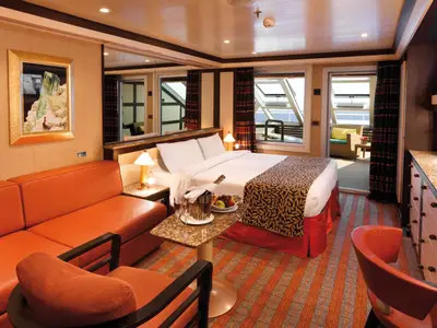 Die luxuriöse Samsara Suite an Bord der Costa Favolosa bietet ein Doppelbett, eine Sitzecke und einen Balkonzugang.