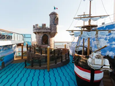 Der farbenfrohe Kinderbereich an Bord der Costa Favolosa mit einer Spielburg und einem Piratenschiff auf dem Außendeck.
