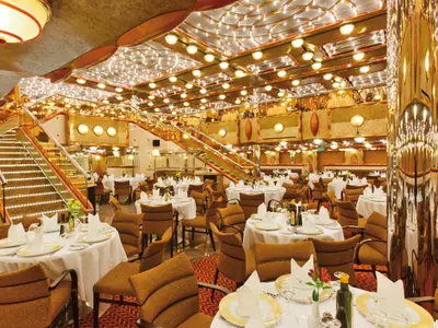 Das prachtvoll und elegant eingedeckte Restaurant Duca d'Orléans an Bord der Costa Favolosa mit goldenen Akzenten.