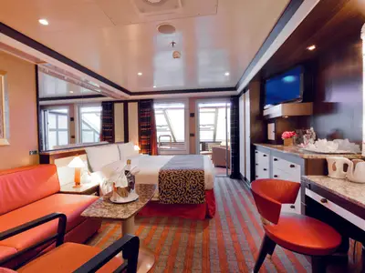 Innenansicht einer geräumigen Samsara Grand Suite mit Veranda und elegantem Design an Bord der Costa Favolosa.