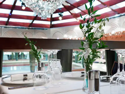 Ein festlich gedeckter Tisch mit Weingläsern, Servietten und Blumenschmuck im Restaurant an Bord der Costa Favolosa.