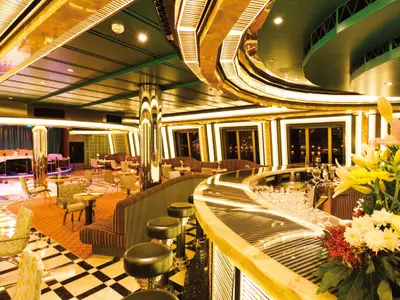 Elegante Bar-Lounge Pompadour an Bord der Costa Favolosa mit einer geschwungenen Bar, Hockern, Tischen und einer Bühne mit Klavier.