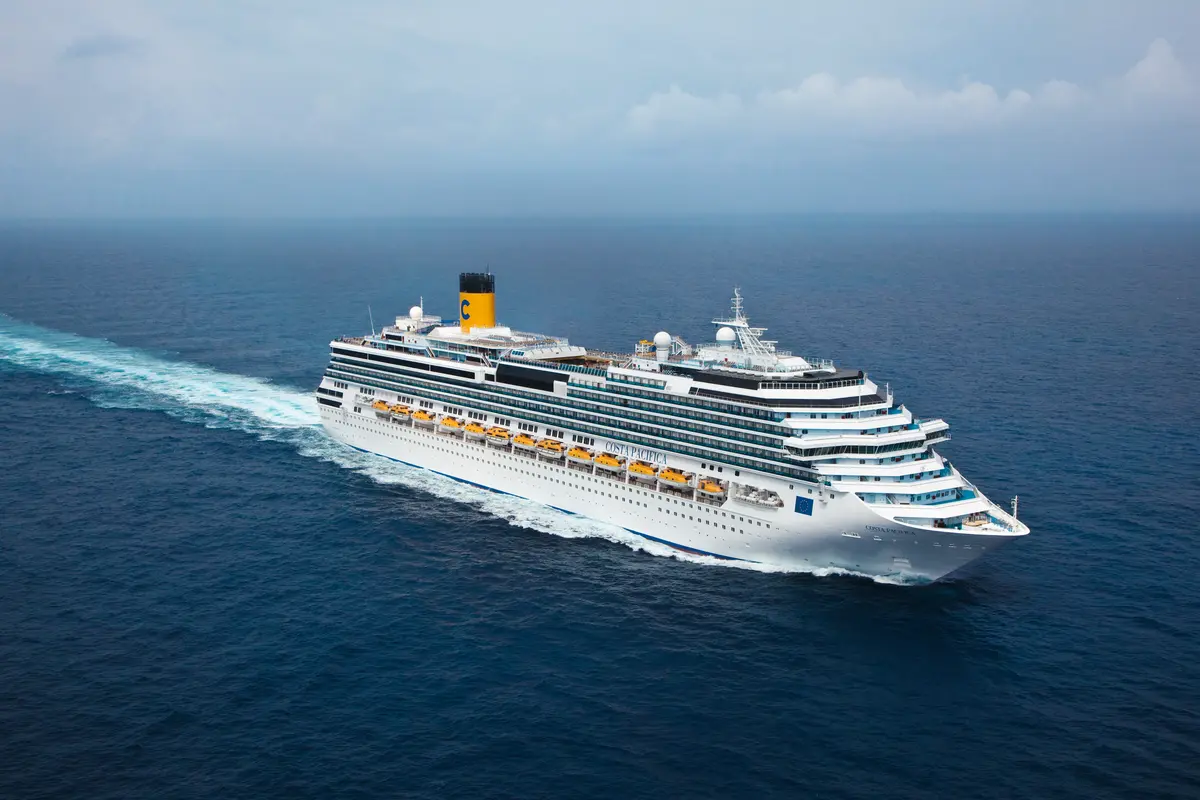 Luftaufnahme der Costa Pacifica, die mit einer langen weißen Heckwelle auf dem blauen Ozean fährt.