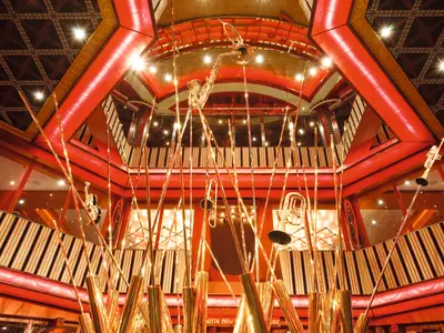 Blick von unten auf die goldenen Musikinstrumente-Skulpturen im prachtvollen Atrium an Bord der Costa Pacifica.