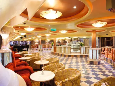 Die Caffetteria Rondò an Bord der Costa Pacifica mit kariertem Boden, gemütlichen Sesseln und musikalischen Details.