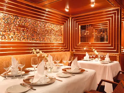 Elegant eingedeckte Tische mit weißen Tischtüchern, Weingläsern und Servietten im Club-Restaurant Blue Moon an Bord der Costa Pacifica.