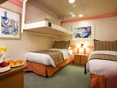 Eine gemütliche Innenkabine an Bord der Costa Serena mit zwei Einzelbetten, einem Pullman-Bett und frischem Frühstück im Vordergrund.