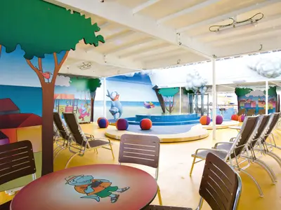 Der farbenfroh gestaltete Squok Club Kinderbereich an Bord der Costa Serena mit Liegestühlen und spielerischer Dekoration.