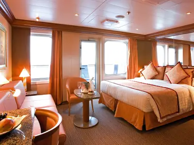 Die luxuriöse Suite an Bord der Costa Serena bietet ein großes Doppelbett, eine Sitzecke und einen Balkon.