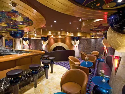 Elegante Bar Classico Ercole an Bord der Costa Serena mit braunen Sesseln, Barhockern und bunten Deckenelementen.