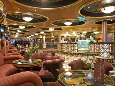 Gemütlicher Loungebereich mit warmem Licht, Sesseln und antiken Dekoelementen in der Caffetteria Juventas an Bord der Costa Serena.