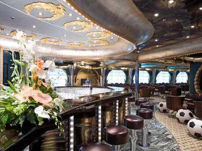 Die Victoria Sport Bar an Bord der Costa Serena mit hockenden Fußball-Sitzen, einer eleganten Theke und Blumenschmuck.