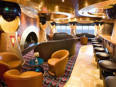 Elegante Bar Classico Ercole an Bord der Costa Serena mit goldenen Elementen, Ledersesseln und Meerblick.