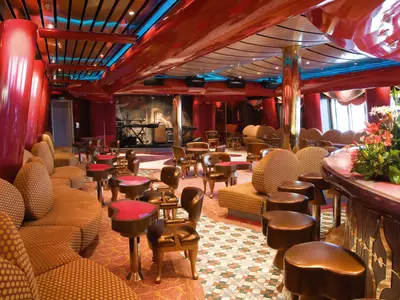Die prachtvolle Cupido Bar an Bord der Costa Serena zeigt herzförmige Sitzgruppen, goldene Säulen und eine geschwungene Theke.