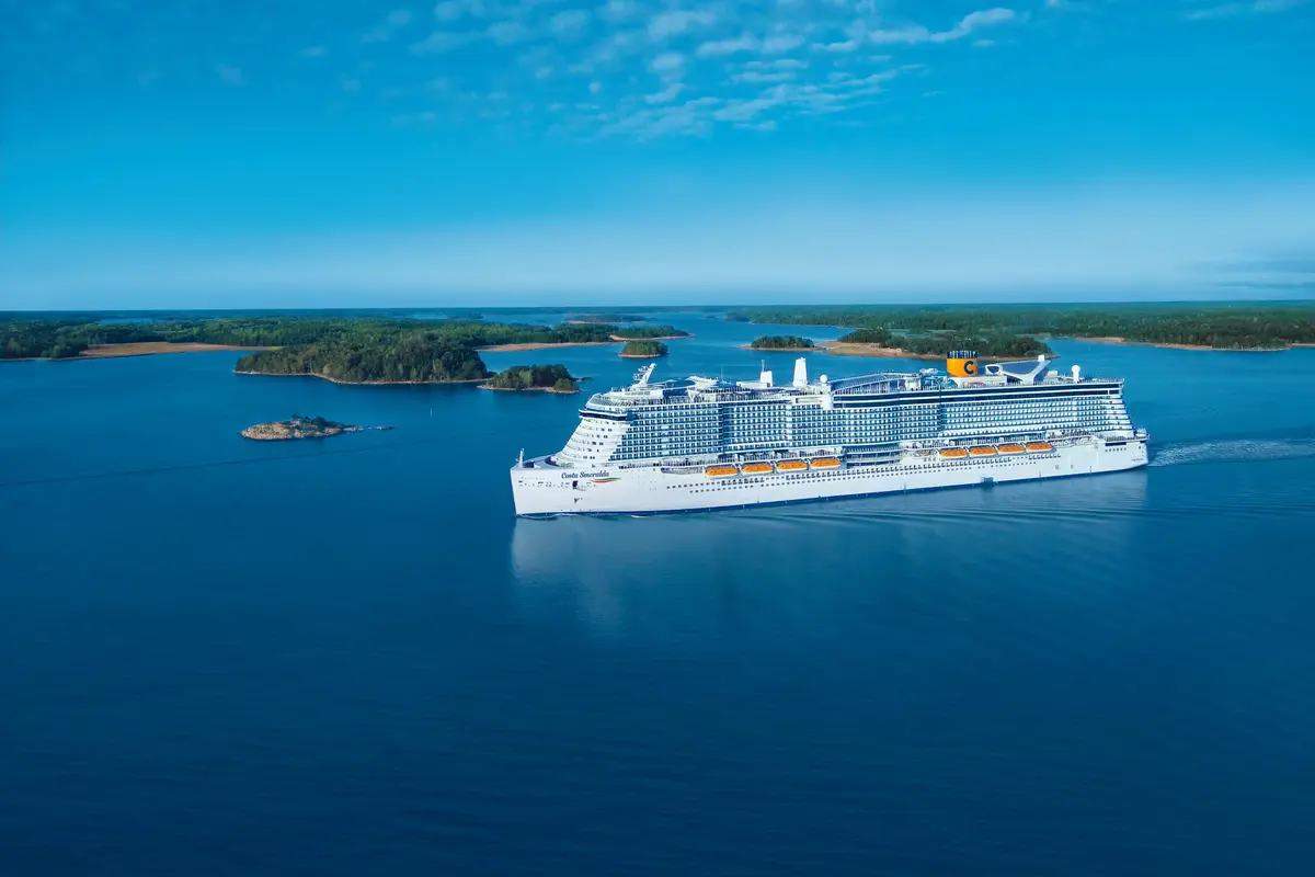 Die Costa Smeralda gleitet bei strahlendem Sonnenschein durch eine ruhige, grüne Insel- und Schärenlandschaft im blauen Meer.