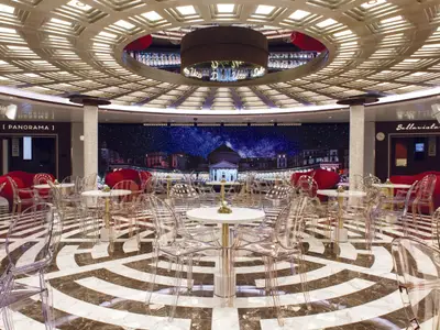 Die Bar Trastevere an Bord der Costa Smeralda besticht durch ein modernes Design mit transparenten Stühlen und einem gemusterten Marmorboden.