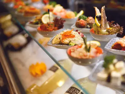 Eine Auswahl an frisch zubereiteten Vorspeisen und Tapas in einer Glasvitrine an Bord der Costa Smeralda.