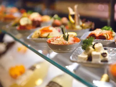 Verschiedene kleine Vorspeisenteller mit Feta-Käse, Meeresfrüchten und Snacks am Buffet an Bord der Costa Smeralda.