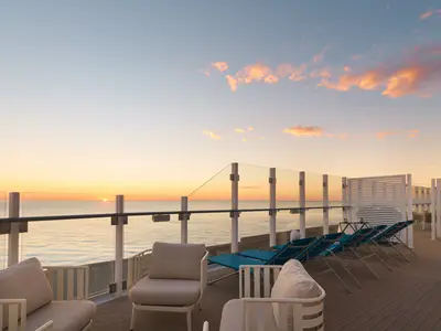 Blick von der Terrazza Infinity an Bord der Costa Toscana auf das weite Meer während eines farbenfrohen Sonnenuntergangs.