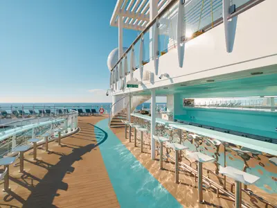 Die stilvolle Bar Orizzonte an Bord der Costa Toscana mit weißen Barhockern, einer geschwungenen Theke, Holzdeck und Blick auf das weite Meer.