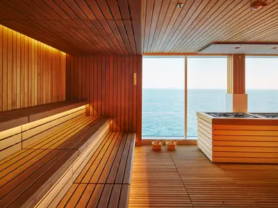 Die moderne Holzsauna Solemio an Bord der Costa Toscana bietet durch ein großes Fenster einen Panoramablick auf das weite blaue Meer.