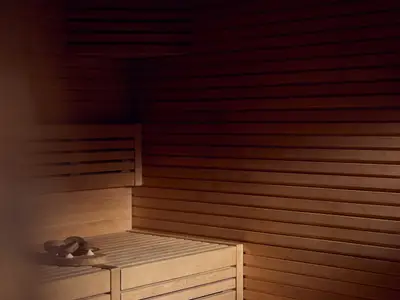Die holzverkleidete Sauna im Ocean Wellness Spa an Bord der Explora I mit einer warmen Lichtstimmung.
