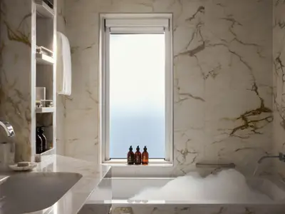 Luxuriöses Badezimmer aus hellem Marmor mit gefüllter Schaumbadewanne und großem Fenster an Bord der Explora I.