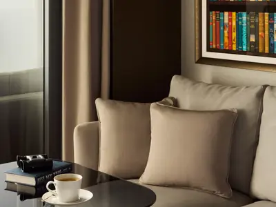 Blick auf beige Kissen auf dem Sofa und einen Beistelltisch in einer Suite an Bord der Explora I.
