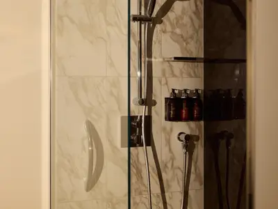 Detailansicht einer modernen Marmordusche mit Pflegeprodukten in einer Suite an Bord der Explora I.