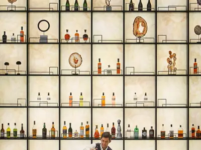 Gitterregal mit beleuchteter Rückwand, edlen Spirituosenflaschen und Kunstobjekten in der Lobby Bar der Explora II.