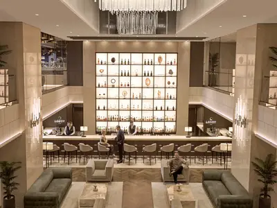 Blick auf die doppelstöckige Lobby Bar an Bord der Explora II mit beleuchtetem Barregal, Gästen und Barpersonal.
