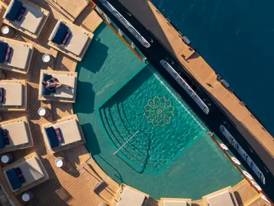 Blick aus der Vogelperspektive auf den Swimmingpool und die bequemen Sonnenliegen an Bord der Explora II.