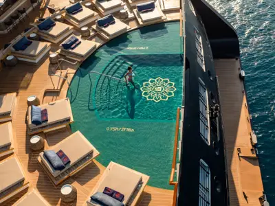 Blick von oben auf den schicken Pool und komfortable Sonnenliegen an Bord der Explora II.