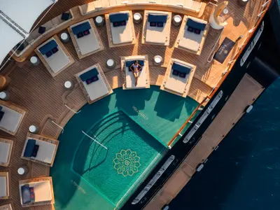 Draufsicht auf einen Pool mit Türkiswasser und luxuriösen Liegen auf dem Außendeck der Explora II.