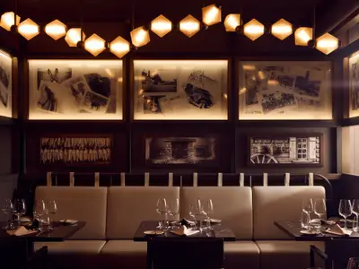 Elegantes Restaurant an Bord der Explora II mit fein eingedeckten Tischen, Wandbildern und cremefarbenen Sitzbänken.