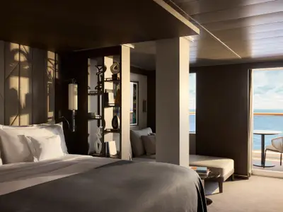 Elegante Penthouse-Suite an Bord der Explora II mit Kingsize-Bett, Regalen und Balkon mit Meerblick.