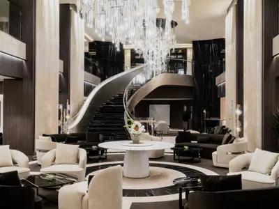 Das elegante Atrium an Bord der Explora III mit beeindruckender Treppe, Kronleuchter und Sitzgelegenheiten.