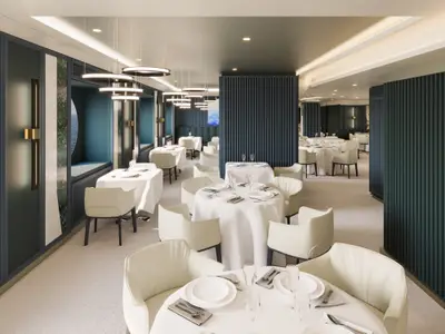 Elegantes Restaurant Fil Rouge an Bord der Explora III mit weiß eingedeckten Tischen und dunkelblauen Lamellenwänden.
