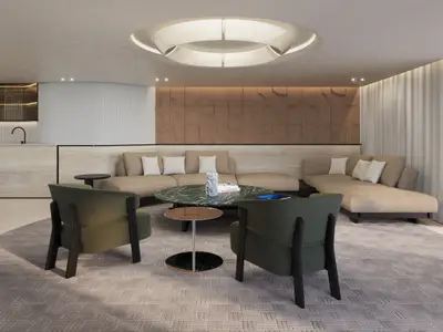 Modern eingerichteter Wohnbereich der Owner's Residence Suite an Bord der Explora III mit zwei grünen Sesseln und Couch.