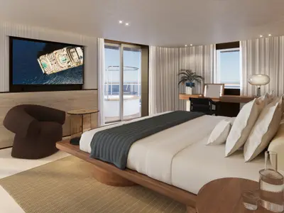 Blick in das moderne Schlafzimmer der Owner's Residence an Bord der Explora III mit Kingsize-Bett, TV und Jacuzzi auf dem Balkon.