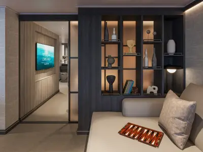 Elegantes Interieur einer Suite an Bord der Explora III mit beleuchtetem Dekoregalelement und gemütlicher Sofaecke.