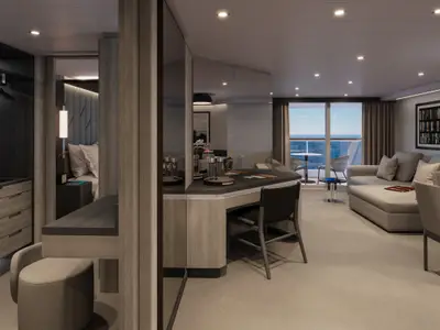 Blick in eine elegante Suite an Bord der Explora III mit Schreibtisch, Sofa, Schlafbereich und Balkon mit Meerblick.